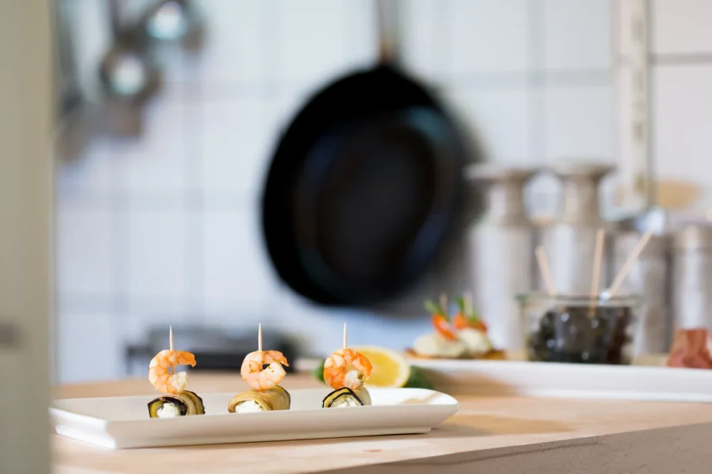 Feine Garnelenspieße auf kleinen Tellern angerichtet als Vorspeise für ein Hochzeits-Catering.