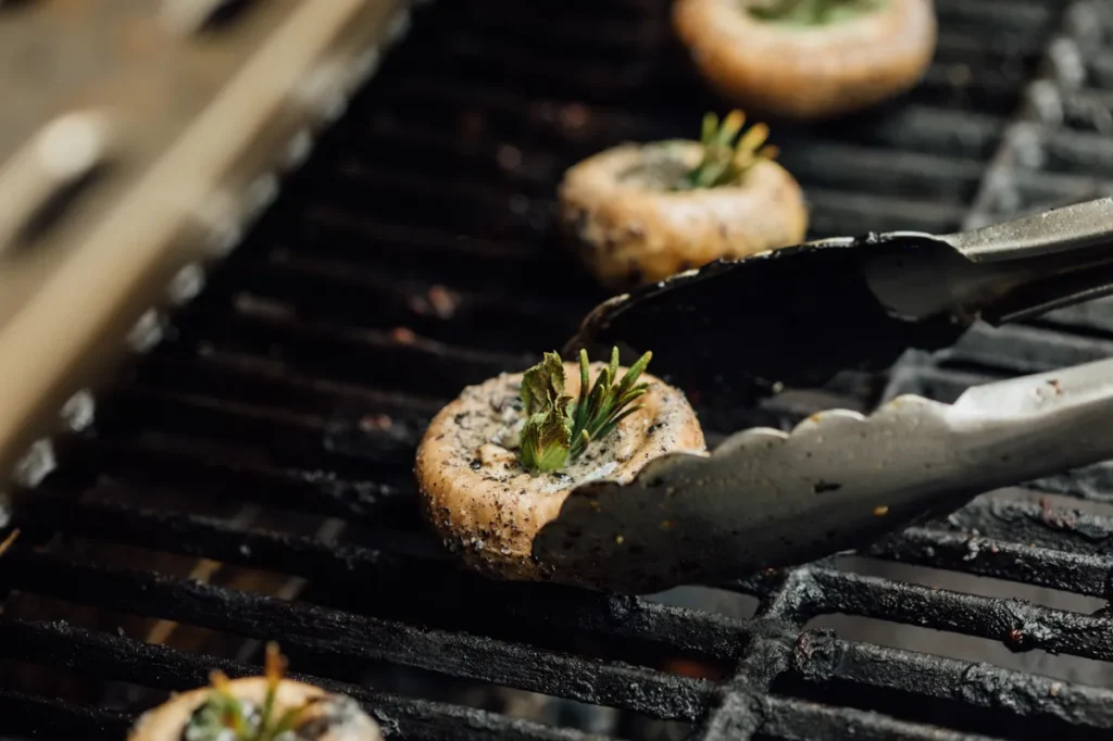 Mit Kräutern gefüllte Champignons werden für ein vegetarisches Barbecue-Catering gegrillt.